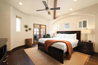 a bedroom with a large bed with a ceiling fan at Coastal Oasis Walk to Ocean Bay and Rooftop Deck in San Diego
