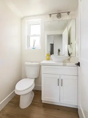 a white bathroom with a toilet and a sink at Ocean Beach Getaway with Peek Views in San Diego