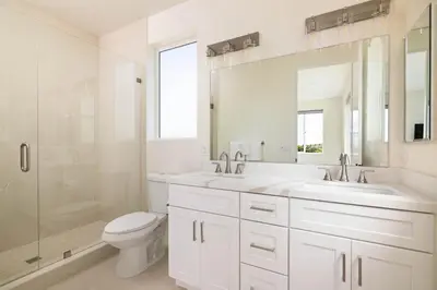 a white bathroom with two sinks and a shower at Ocean Beach Getaway with Peek Views in San Diego