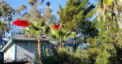 a house with two red umbrellas on top of it at La Casita Private Resort Spa and Mini Golf Course in Alpine
