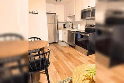 a kitchen with stainless steel appliances and a table and chairs at Stylish 1BR Near Downtown, Beaches & North Park in San Diego