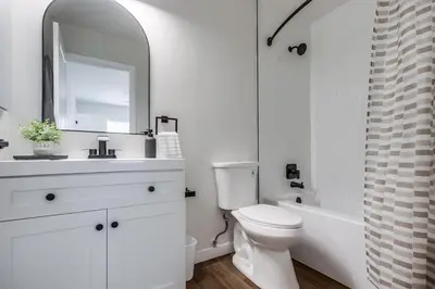 a bathroom with a sink and a toilet and a mirror at Stylish 1BR Near Downtown, Beaches & North Park in San Diego