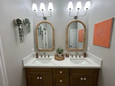 a bathroom with two sinks and two mirrors at Beach Oasis in Carlsbad Village in Carlsbad