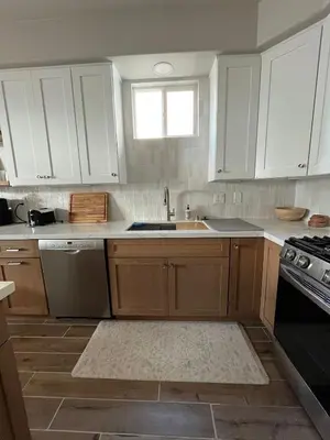a kitchen with white cabinets and a sink at Beach Oasis in Carlsbad Village in Carlsbad