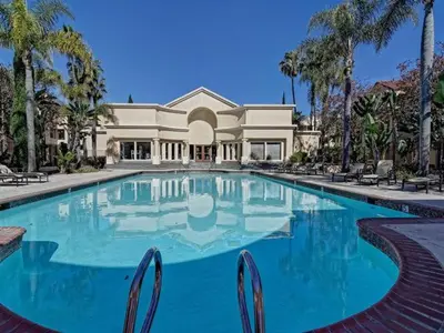 a large swimming pool in front of a house at --Vacation First floor luxury condo La Jolla, Spa, Pool, Gym in San Diego