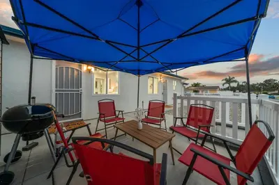 a patio with chairs and a grill and a blue umbrella at Entire Private Home with 3 Bedrooms 3 Bathrooms, House with Yard, King Bed, Prime Location, Available Now in San Diego