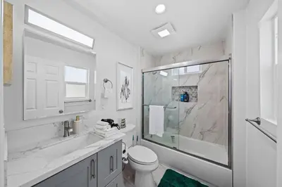 a white bathroom with a toilet and a shower at Entire Private Home with 3 Bedrooms 3 Bathrooms, House with Yard, King Bed, Prime Location, Available Now in San Diego