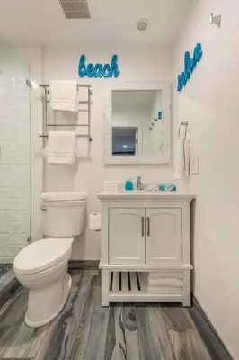 a bathroom with a toilet and a sink and a mirror at Modern Surf Themed Home - Heart of Gaslamp in San Diego