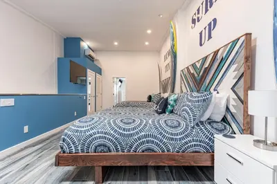 a bedroom with a large bed with blue walls at Modern Surf Themed Home - Heart of Gaslamp in San Diego