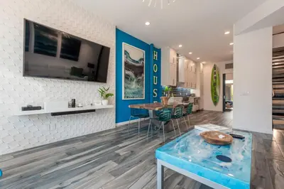 a living room with a blue table and a kitchen at Modern Surf Themed Home - Heart of Gaslamp in San Diego