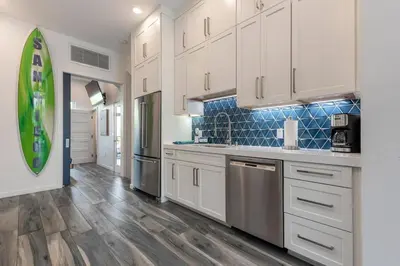 a kitchen with white cabinets and stainless steel appliances at Modern Surf Themed Home - Heart of Gaslamp in San Diego