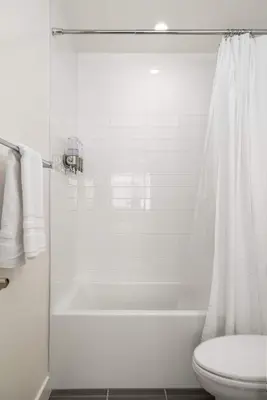 a white bathroom with a tub and a toilet at NEW 3br Luxury Townhome - Gaslamp - Balboa Park in San Diego