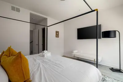 a bedroom with a large white bed and a tv at NEW 3br Luxury Townhome - Gaslamp - Balboa Park in San Diego