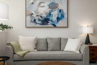 a living room with a couch and a painting on the wall at NEW 3br Luxury Townhome - Gaslamp - Balboa Park in San Diego