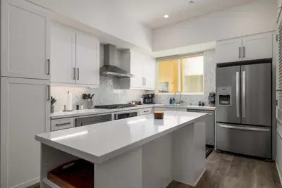 a kitchen with white cabinets and a large white island at NEW 3br Luxury Townhome - Gaslamp - Balboa Park in San Diego