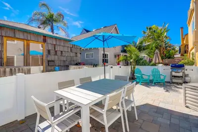 a table with chairs and an umbrella on a patio at Steps to Bay & Beach, Rooftop Deck, Fire Pit, AC, Garage, Views in San Diego