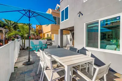 a table with chairs and an umbrella on a patio at Steps to Bay & Beach, Rooftop Deck, Fire Pit, AC, Garage, Views in San Diego