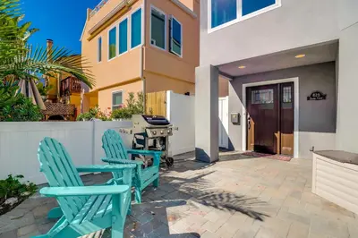 a patio with two chairs and a grill in front of a house at Steps to Bay & Beach, Rooftop Deck, Fire Pit, AC, Garage, Views in San Diego