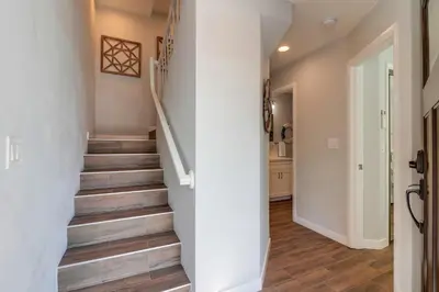 a staircase in a home with wood flooring at Steps to Bay & Beach, Rooftop Deck, Fire Pit, AC, Garage, Views in San Diego