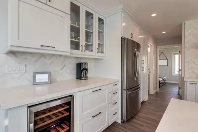a kitchen with white cabinets and a refrigerator at Steps to Bay & Beach, Rooftop Deck, Fire Pit, AC, Garage, Views in San Diego