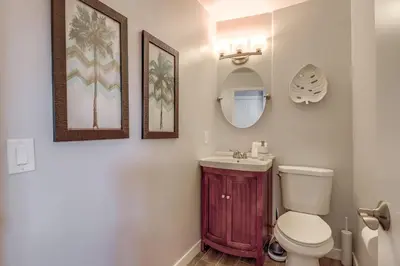 a bathroom with a toilet and a sink and a mirror at Steps to Bay & Beach, Rooftop Deck, Fire Pit, AC, Garage, Views in San Diego