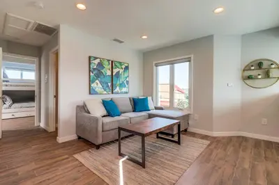 a living room with a couch and a table at Steps to Bay & Beach, Rooftop Deck, Fire Pit, AC, Garage, Views in San Diego