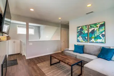 a living room with a couch and a table at Steps to Bay & Beach, Rooftop Deck, Fire Pit, AC, Garage, Views in San Diego