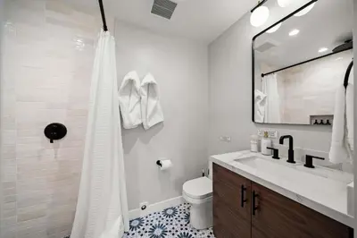 a bathroom with a sink and a toilet and a mirror at Del Mar Retreat - Laundry BBQ Firepit AC Patio in San Diego