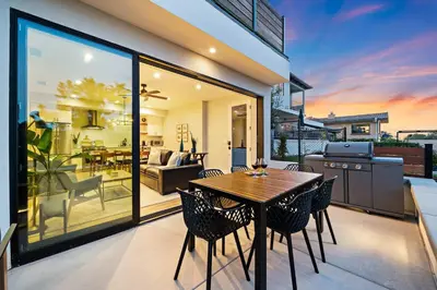a dining room with a table and chairs on a balcony at Del Mar Retreat - Laundry BBQ Firepit AC Patio in San Diego