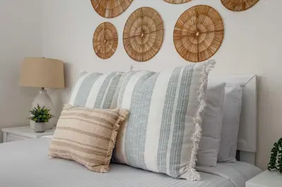 a bedroom with a bed with pillows and clocks on the wall at Chic Beach Retreat - Newly Furnished 1BR in Ocean Beach! in San Diego