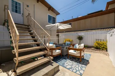 a patio with a table and chairs and a staircase at Chic Beach Retreat - Newly Furnished 1BR in Ocean Beach! in San Diego