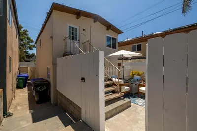 a house with a white fence in front of it at Chic Beach Retreat - Newly Furnished 1BR in Ocean Beach! in San Diego