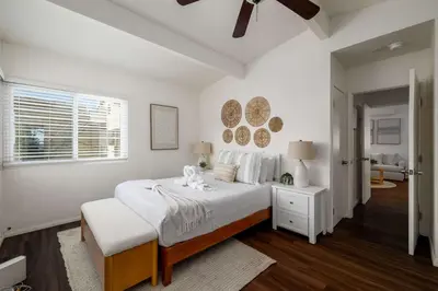a white bedroom with a bed and a window at Chic Beach Retreat - Newly Furnished 1BR in Ocean Beach! in San Diego