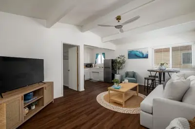 a living room with a couch and a flat screen tv at Chic Beach Retreat - Newly Furnished 1BR in Ocean Beach! in San Diego