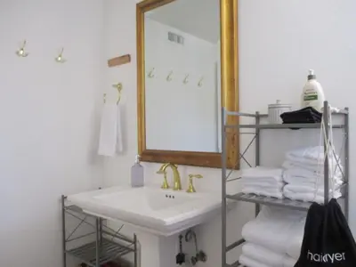 a bathroom with a sink and a mirror and towels at Saint Ann's Court in Laguna Beach