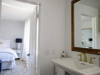 a bathroom with a sink and a bed and a mirror at Saint Ann's Court in Laguna Beach