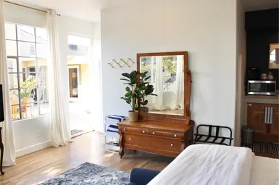 a bedroom with a mirror and a dresser with a plant on it at Saint Ann's Court in Laguna Beach