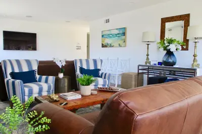 a living room with a leather couch and chairs at Saint Ann's Court in Laguna Beach