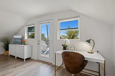 a white desk and a chair in a room with windows at Ocean-View, Deck, Steps to Beach Dining and More in Solana Beach