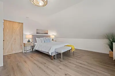a white bedroom with a bed and a wooden floor at Ocean-View, Deck, Steps to Beach Dining and More in Solana Beach