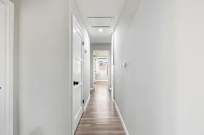 a hallway with white walls and wooden floors at Bay Park Bliss Ocean Views Pickleball and Jacuzzi in San Diego