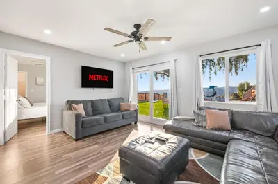 a living room with a couch and a ceiling fan at Bay Park Bliss Ocean Views Pickleball and Jacuzzi in San Diego