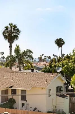 a white house with palm trees in the background at Coastal Ocean Beach Compound Escape in San Diego