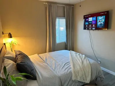 a bedroom with a bed with a tv on the wall at Cozy Home in National City 15 min from San Diego in National City