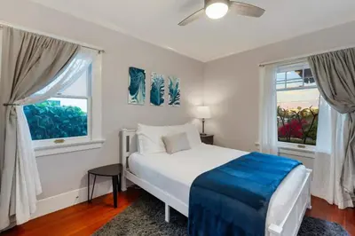 a bedroom with a white bed and two windows at Stylish 2BR Home and Studio Great Central Location in San Diego