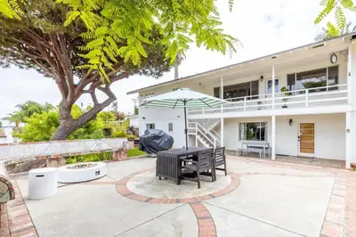 a bench and an umbrella in front of a house at 3Bed Single Level Home in Carlsbad
