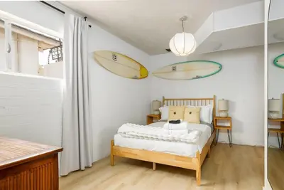 a bedroom with a bed with two surfboards on the wall at Spacious 2 Bed in Carlsbad in Carlsbad