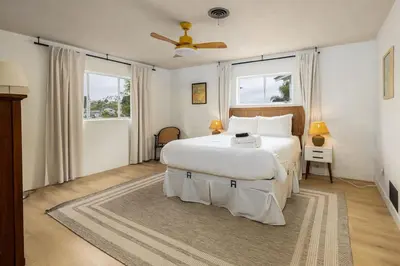 a bedroom with a large white bed and two windows at Spacious 2 Bed in Carlsbad in Carlsbad