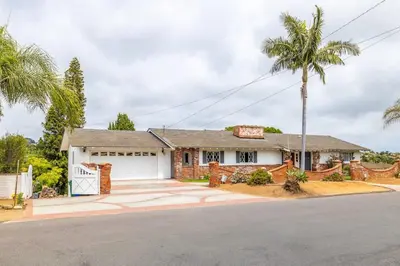 a house with a palm tree in front of it at Spacious 2 Bed in Carlsbad in Carlsbad