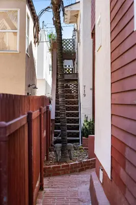 a stairway with a palm tree next to a building at Cute Home Steps from the Sand in San Diego
